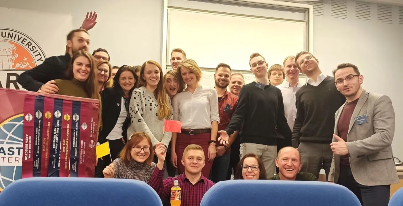 Zdjęcie grupowe z szarfami i banerem Toastmasters